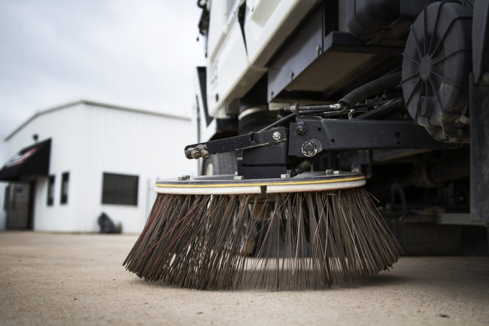 Close up of the gutter broom on a More Clean of Texas sweeper truck