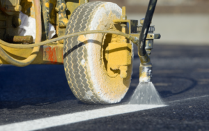 Line striping machine painting fresh white lines while completing Line Striping Service