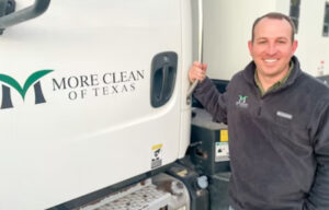 More Clean of Texas president Cole Watts next to a sweeper truck.