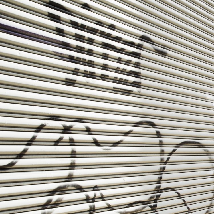 Unsightly Graffiti on a metal roll up door.
