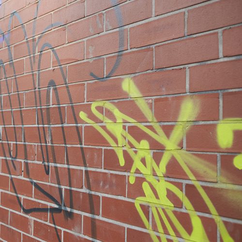 Unsightly spray painted graffiti on a brick wall